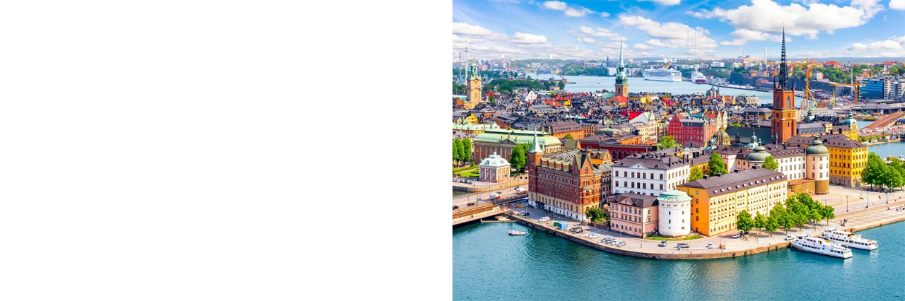Luftbild von Stockholms Altstadt mit bunten Häusern am Wasser.