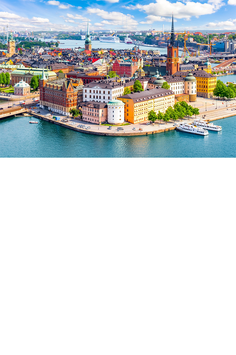 Luftbild von Stockholms Altstadt mit bunten Häusern am Wasser.