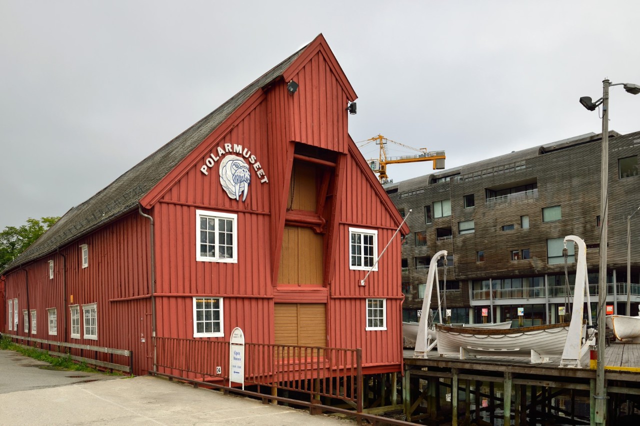 Rotes Polar Museum am Kai mit Boot im Vordergrund in Tromsø.
