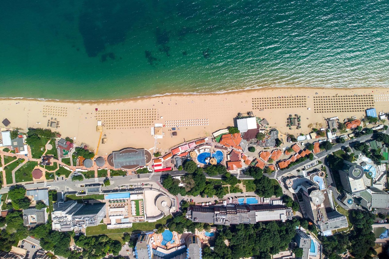 Luftbild vom Goldstrand mit Strandliegen, Hotels und blauem Meer.