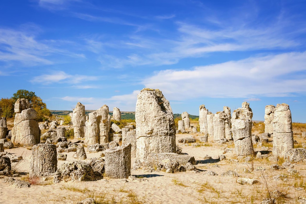 Steinformation Pobiti Kamani mit aufrecht stehenden Felsen in Sandlandschaft.