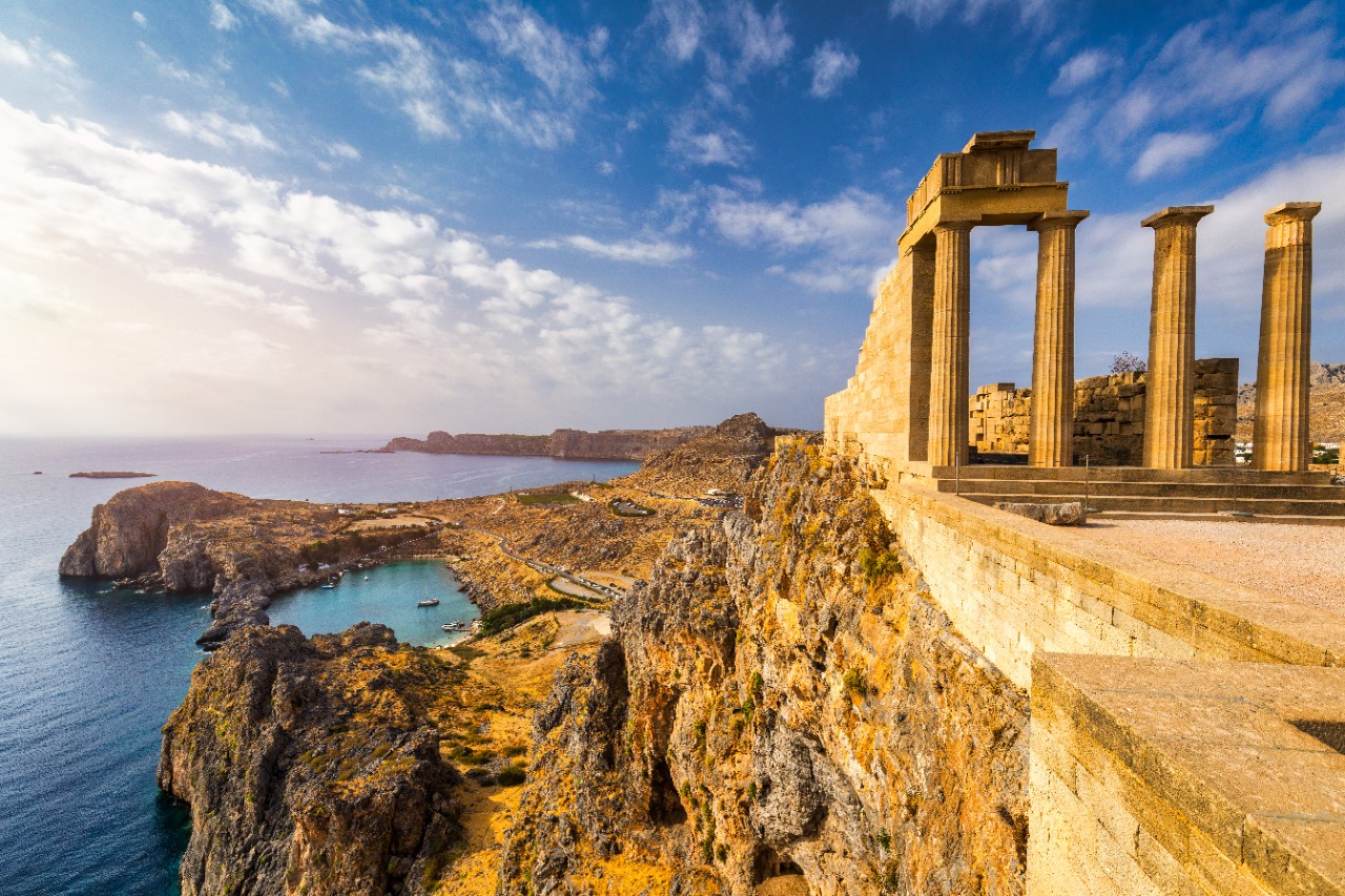 Antike Akropolis auf einem Felsen über weißen Häusern in Lindos, Rhodos.