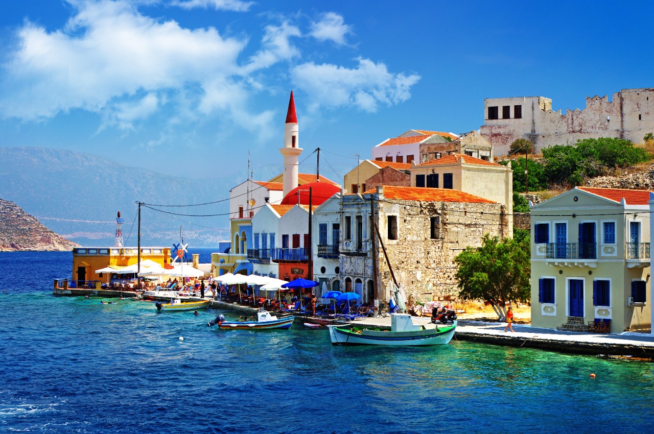 Hafen von Megisti auf Kastellorizo mit bunten Häusern am Wasser.