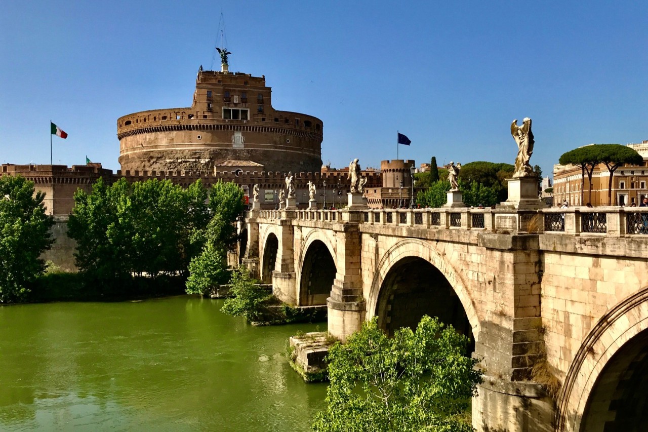 Engelsburg mit Statue verzierter Brücke über den Tiber.