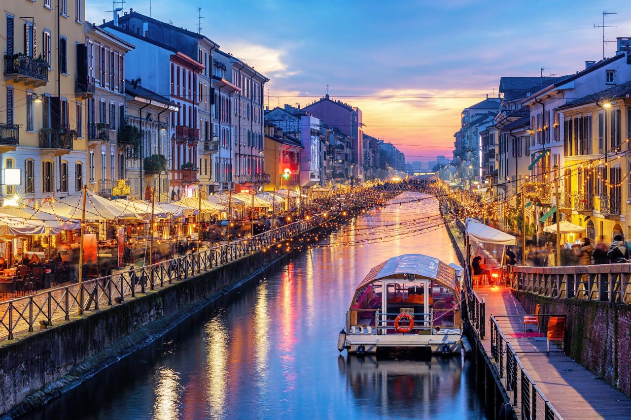 Beleuchtete Kanäle im Navigli-Viertel mit Lokalen am Abend.