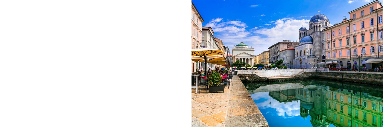 Innenstadt von Triest: Elegante Häuser und Paläste entlang eines Kanals, in dem sie sich spiegeln, Straßencafé mit Sonnenschirmen und Pflanzen. 