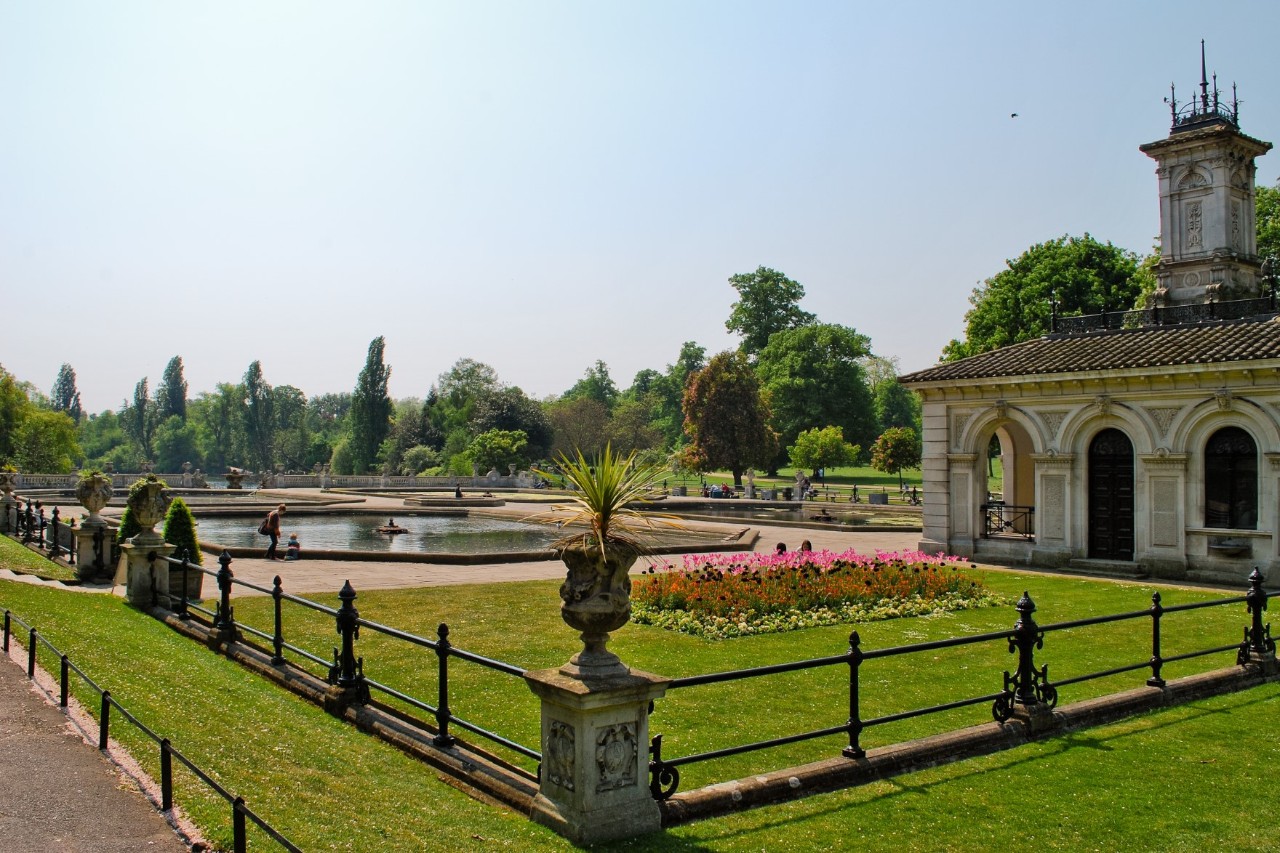 Weitläufige Grünfläche im Hyde Park mit Bäumen und Spazierwegen.