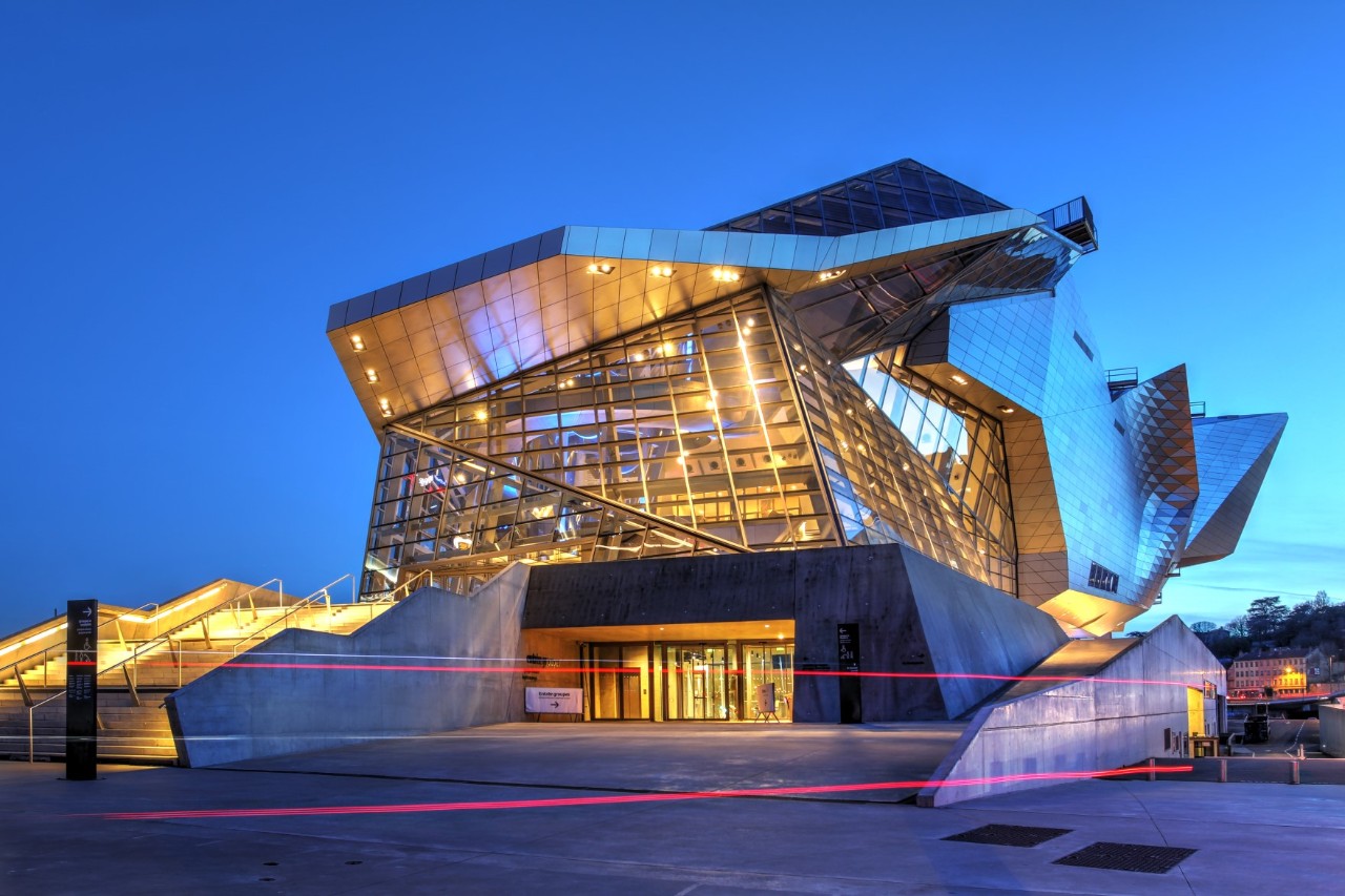 Modernes Museum Confluences mit beleuchteter Glasarchitektur.