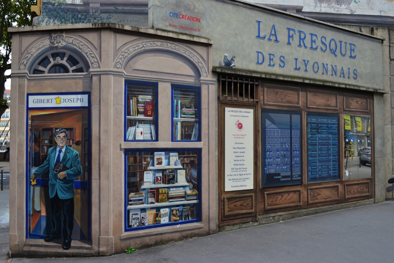 Wandfreske mit Buchladen-Motiv in Lyon.