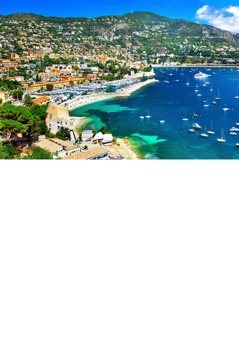 Panoramablick auf Nizza, besiedelte grüne Hänge, Hafen und Strand, blauer Ozean mit vielen kleinen Segelbooten 