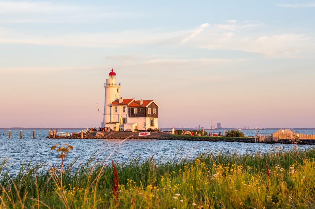 Weißer Leuchtturm auf der Insel Marken vor blauem Himmel.
