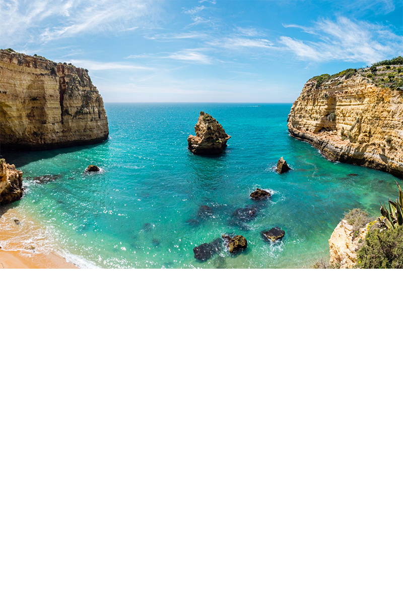 Meeresbucht mit türkisblauem Wasser und Steilküste an der Algarve 