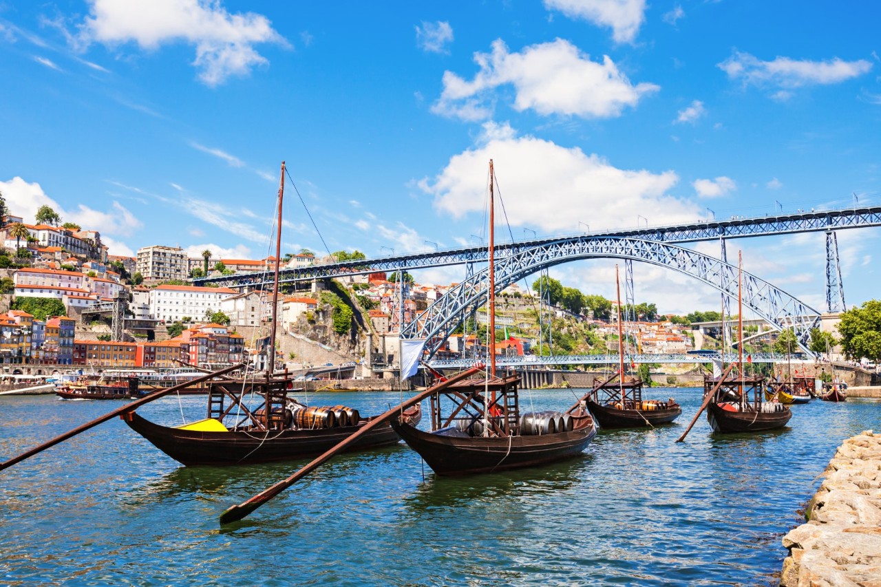 Boote auf dem Douro vor der Brücke Dom Luís I in Porto.