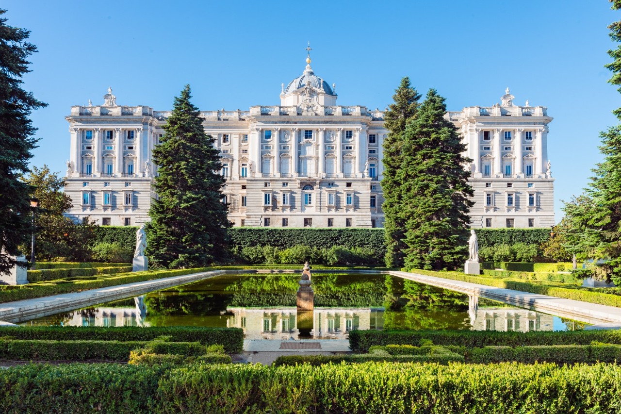 Blick auf den Königspalast von Madrid mit Garten und Teich.