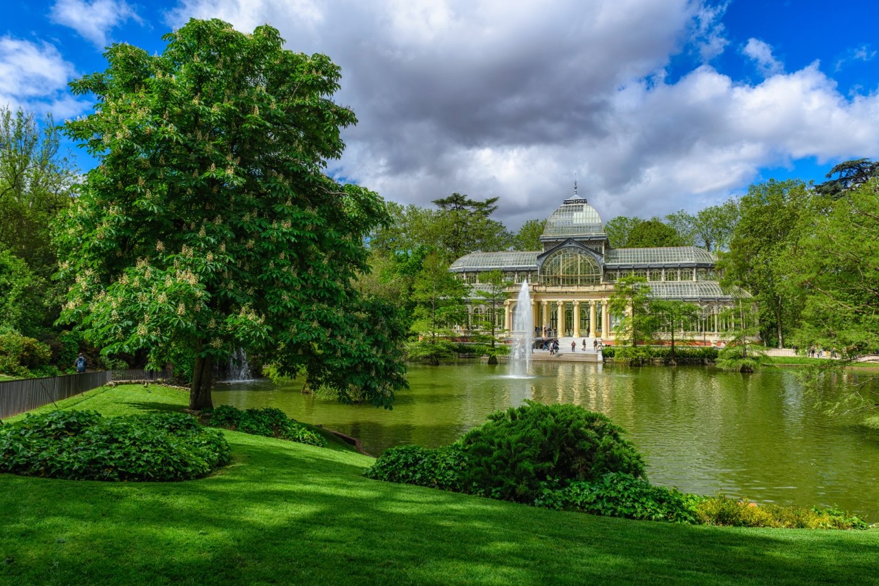 Blick auf den Kristallpalast im Retiro-Park mit See.