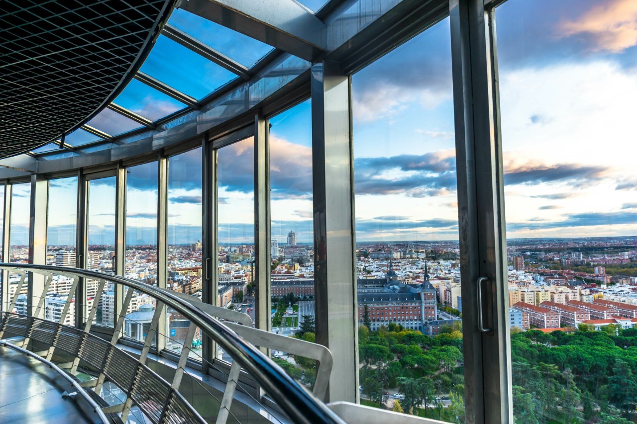 Innenansicht mit Panorama auf Madrid durch große Glasfenster.