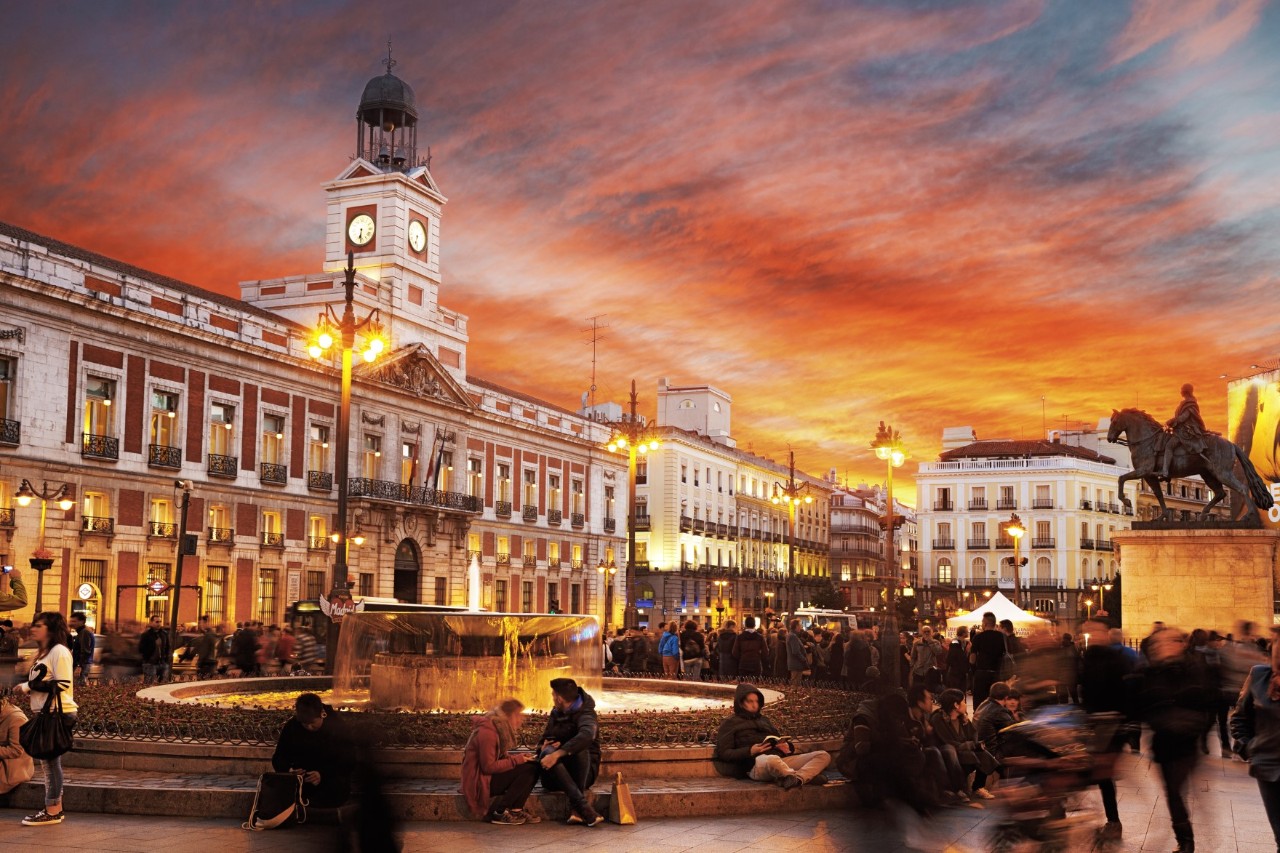 Platz Puerta del Sol bei Sonnenuntergang mit Menschenmenge.
