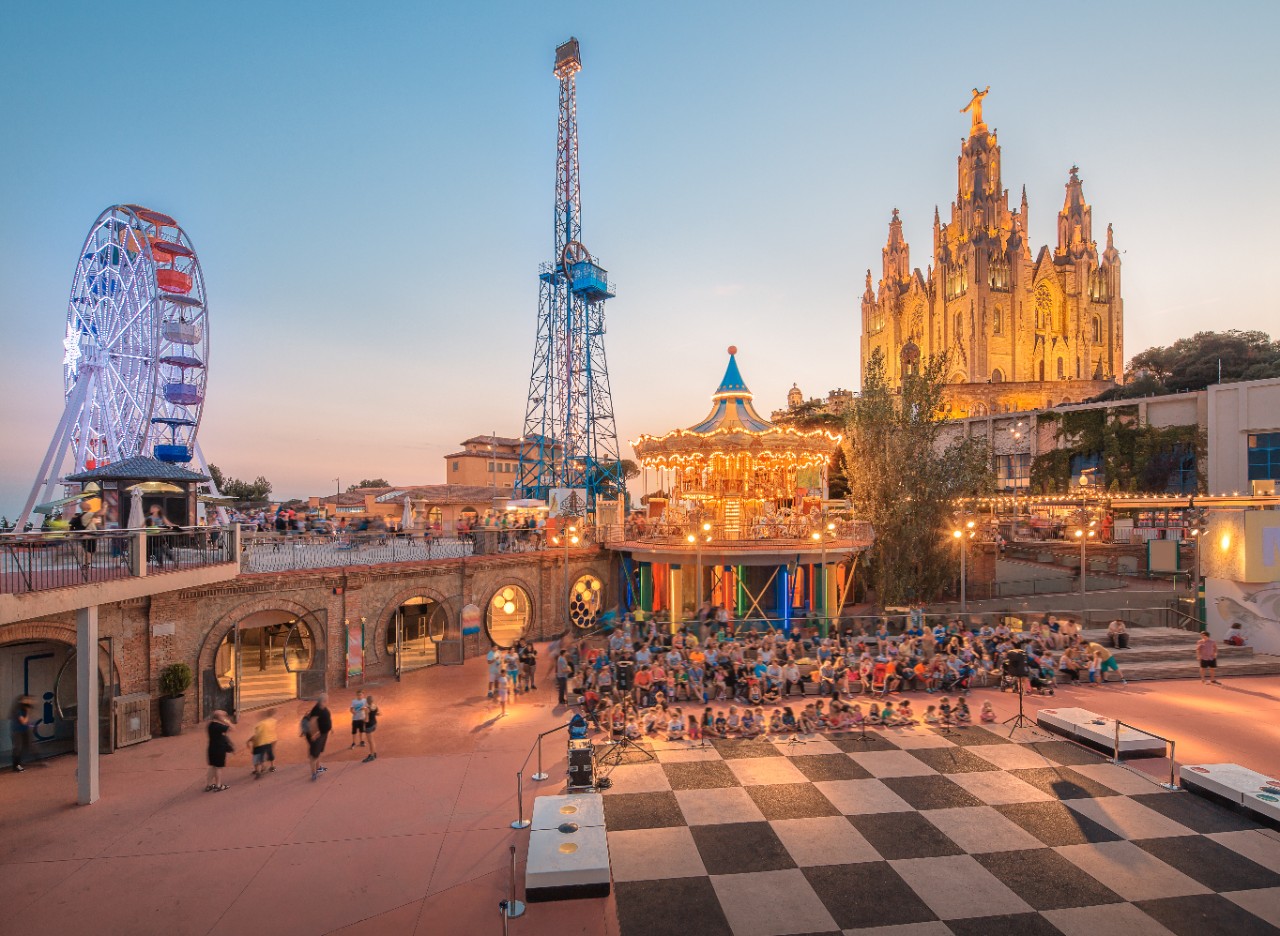Tibidabo mit Kirche und Freizeitpark über der Stadt bei klarem Himmel.