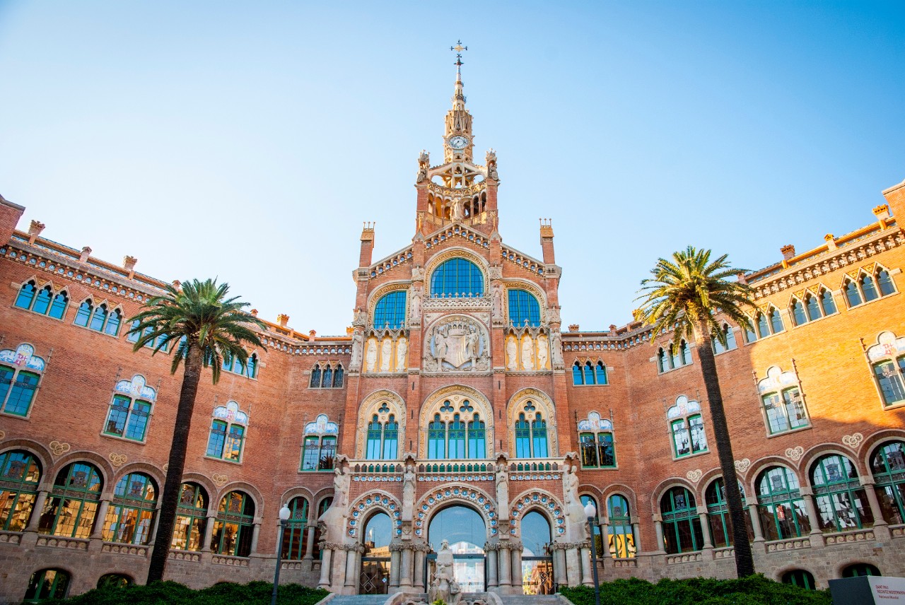 Jugendstil-Gebäude des Hospital de Sant Pau mit Turm und Ziegelfassade.