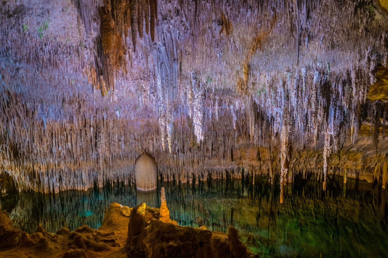 Höhle Coves del Drac auf Mallorca mit Stalagmiten und Stalaktiten und unterirdischem See 
