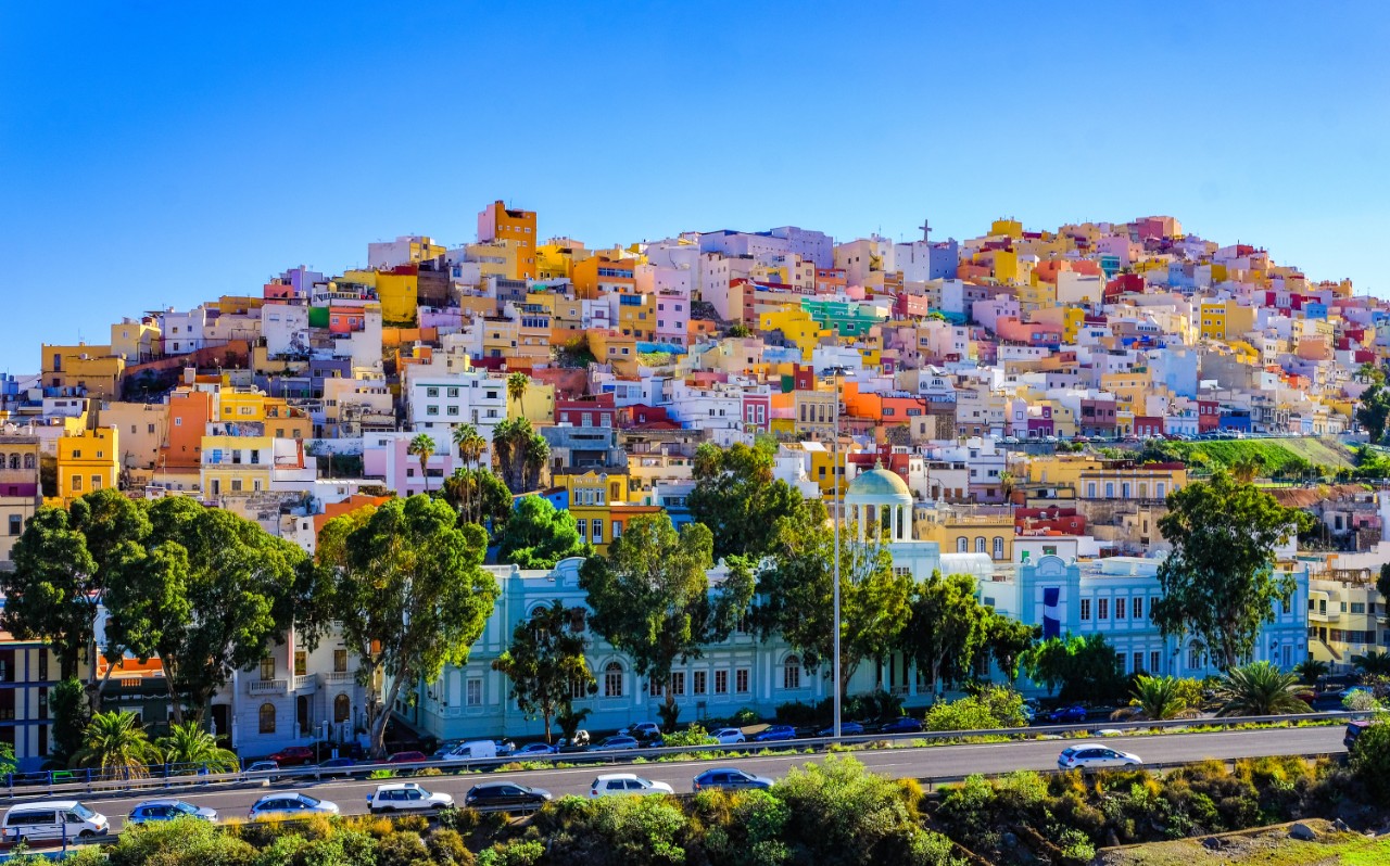 Bunte Häuser auf Hügel in Las Palmas mit engen Gassen und Kirchen.