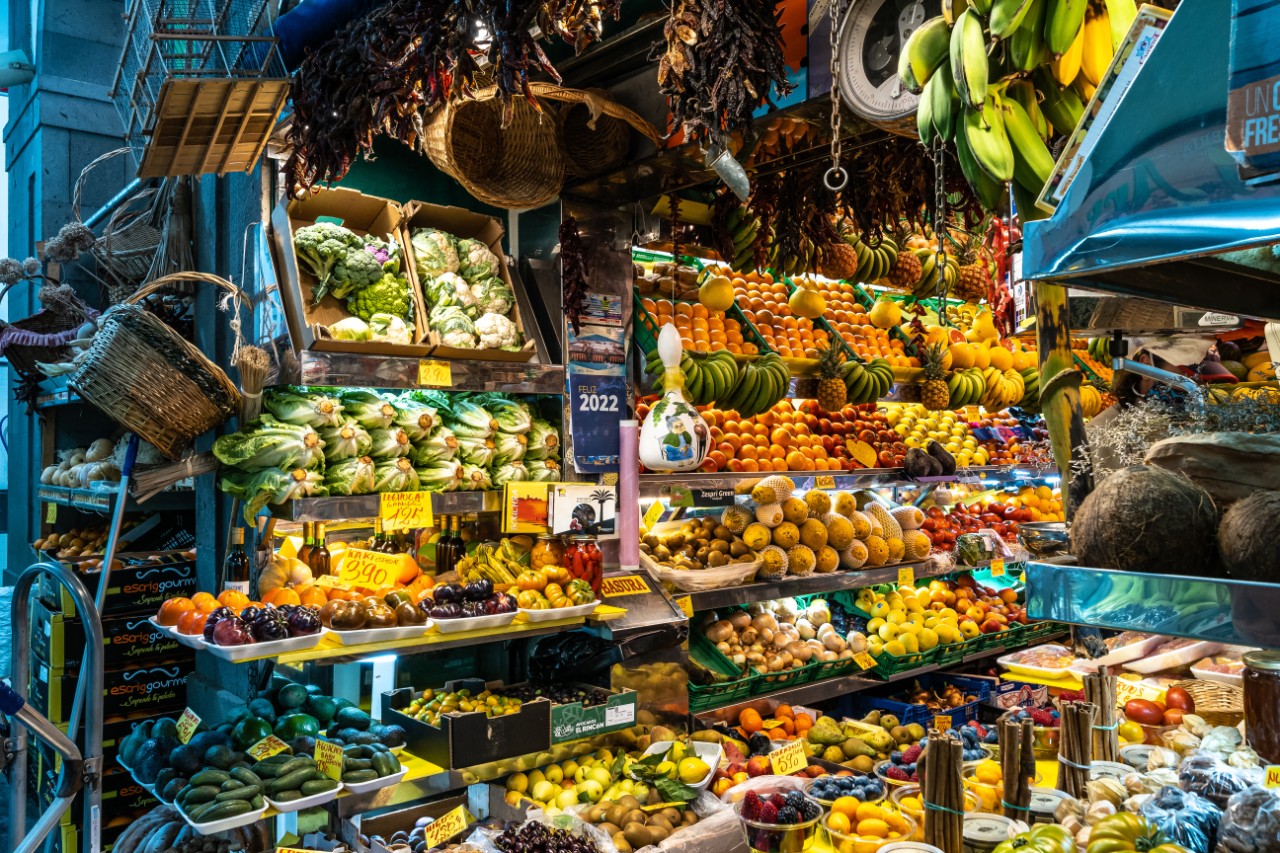 Markthalle in der Altstadt mit frischem Obst und Gemüse an bunten Ständen.