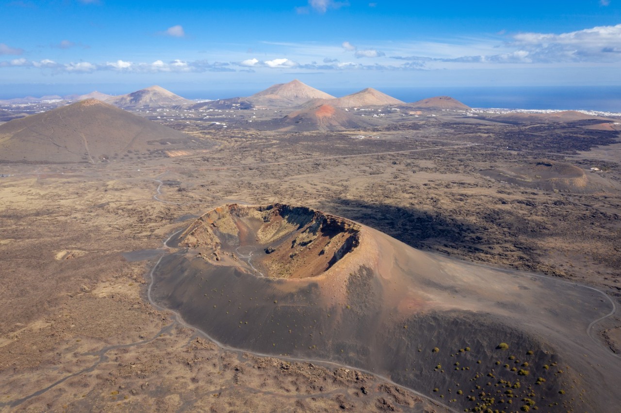 Weite Lavalandschaft mit Hügeln und karger Vegetation auf Lanzarote.