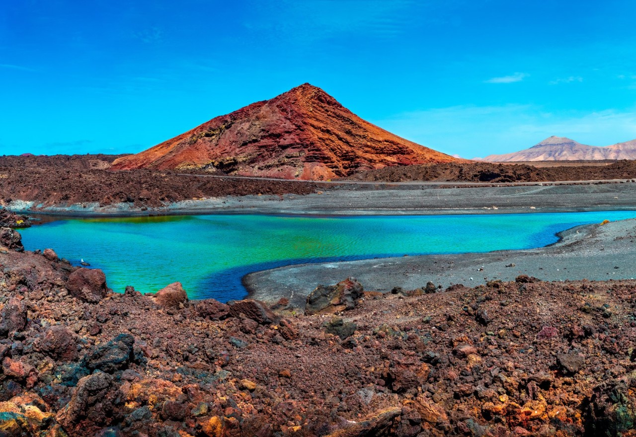 Küstenlandschaft mit blauem Meer und Vulkan auf Lanzarote.