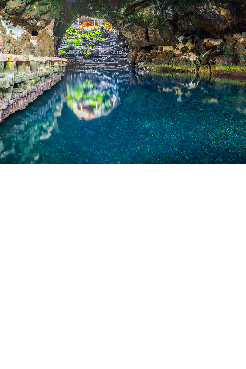 Höhle mit türkisfarbenem Wasser und heller Felsdecke auf Lanzarote.