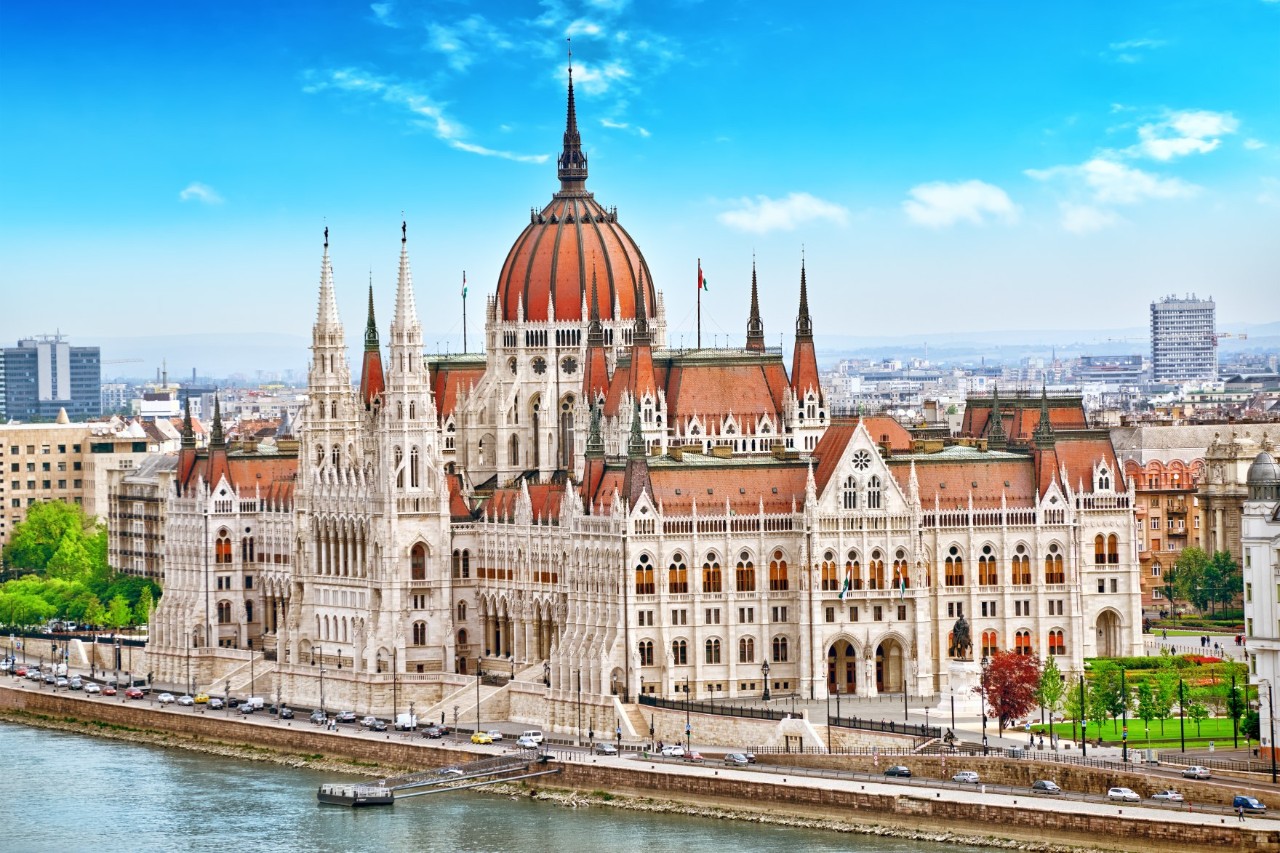Parlamentsgebäude Budapest mit Türmen und roter Kuppel.