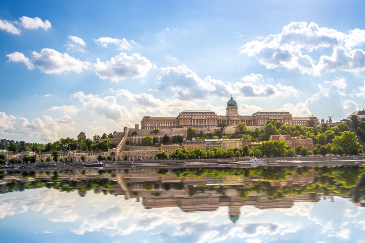 Burgpalast mit Kuppel und Spiegelung im Wasser.