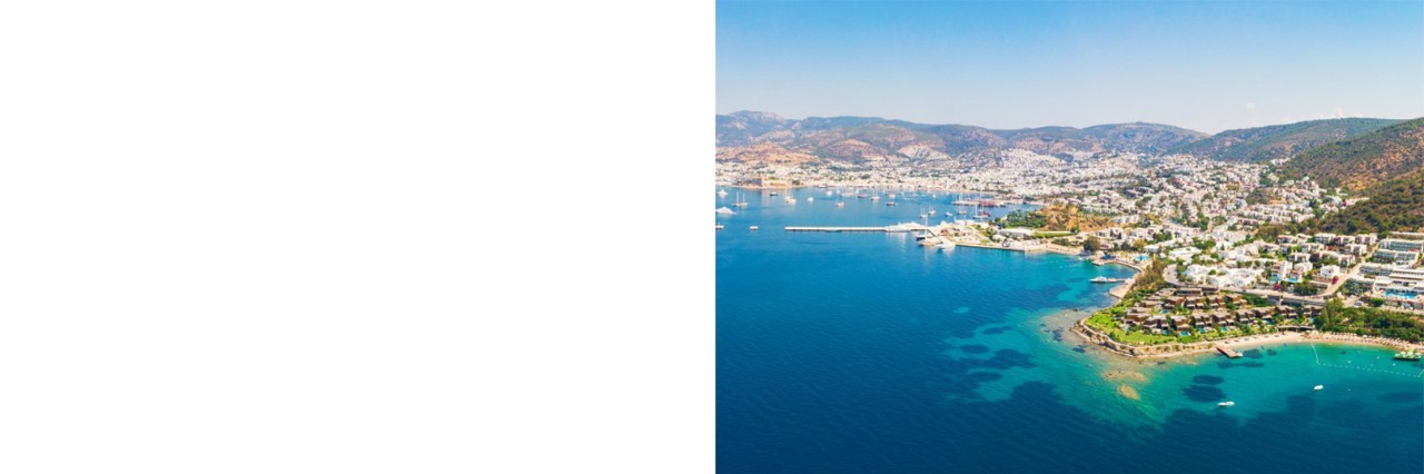 Luftbild von der Küste bei Bodrum mit blauem Meer und grüner Hügellandschaft.