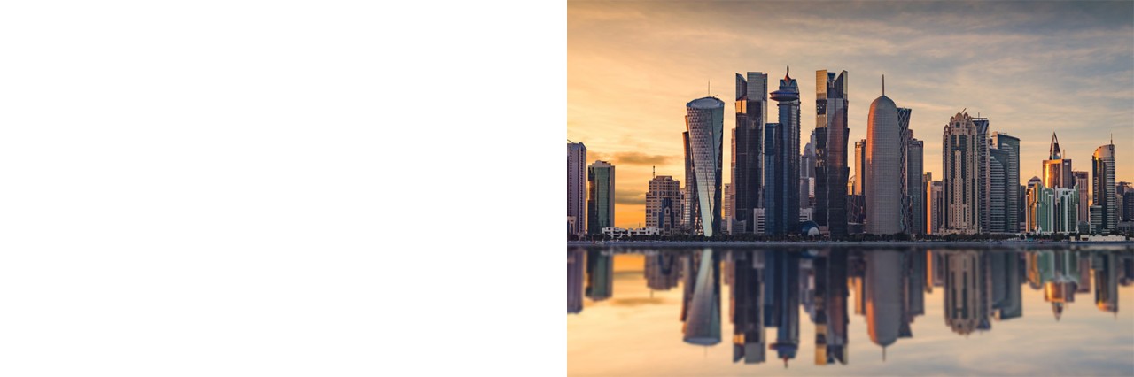 Skyline von Doha spiegelt sich im Wasser bei Abendstimmung.