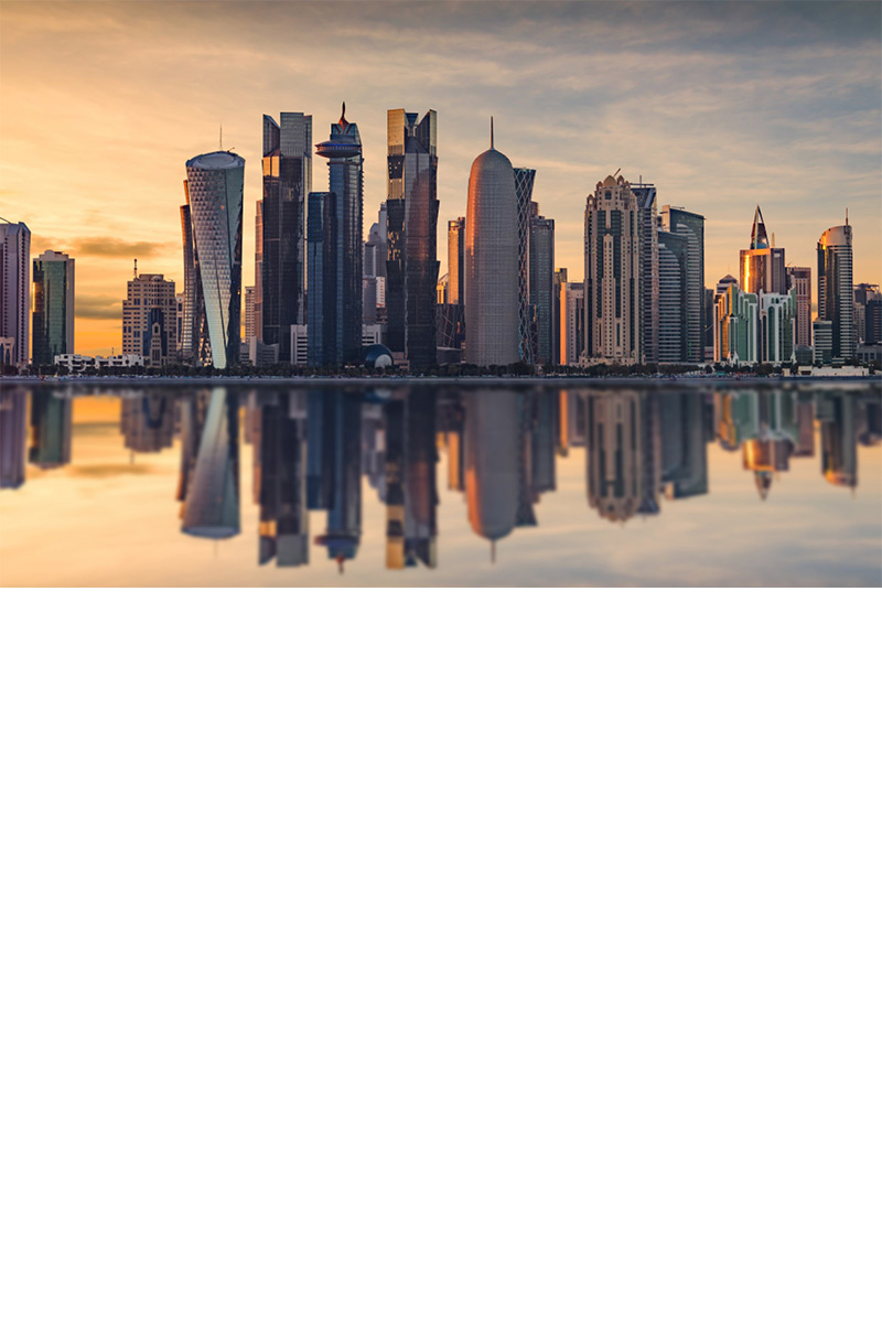 Skyline von Doha spiegelt sich im Wasser bei Abendstimmung.