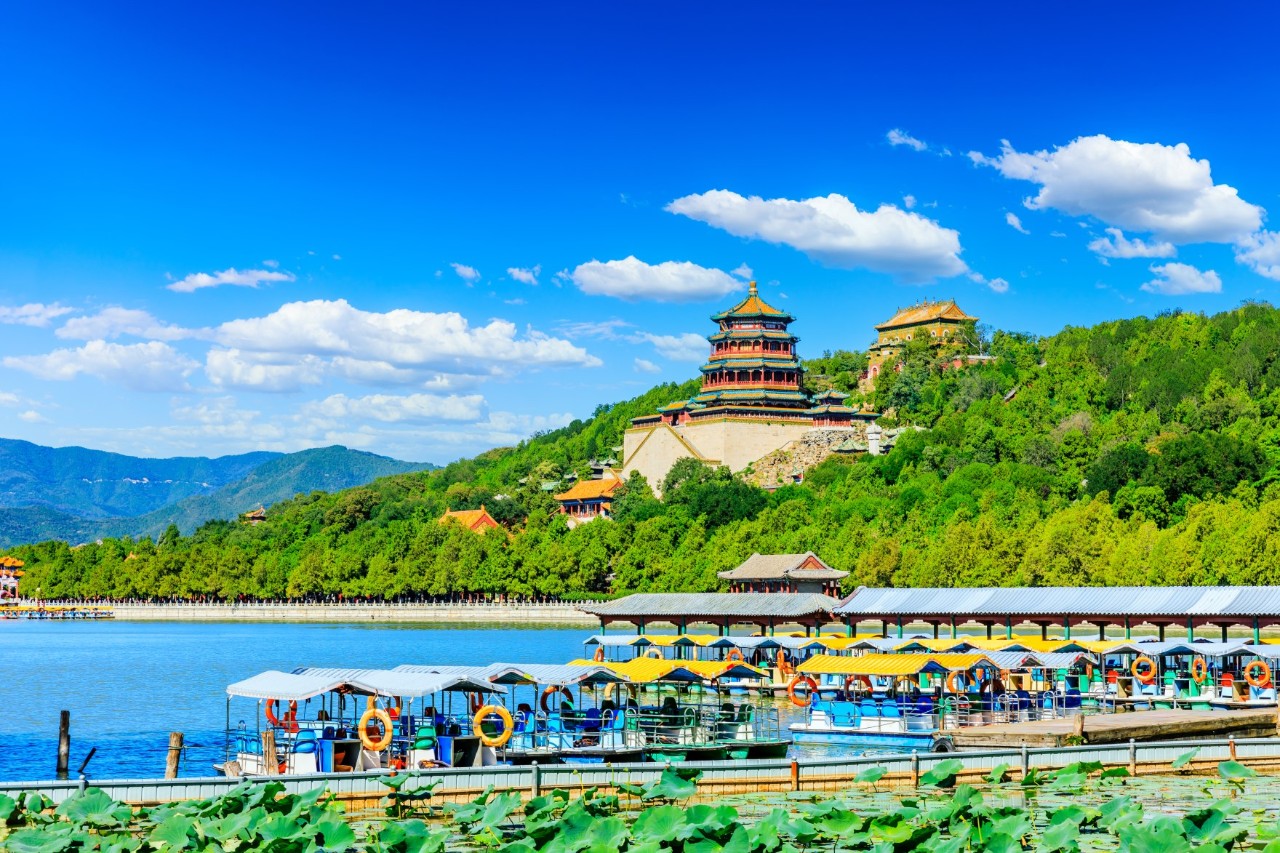 Sommerpalast in Peking mit Pavillon, See und bewaldetem Hügel.