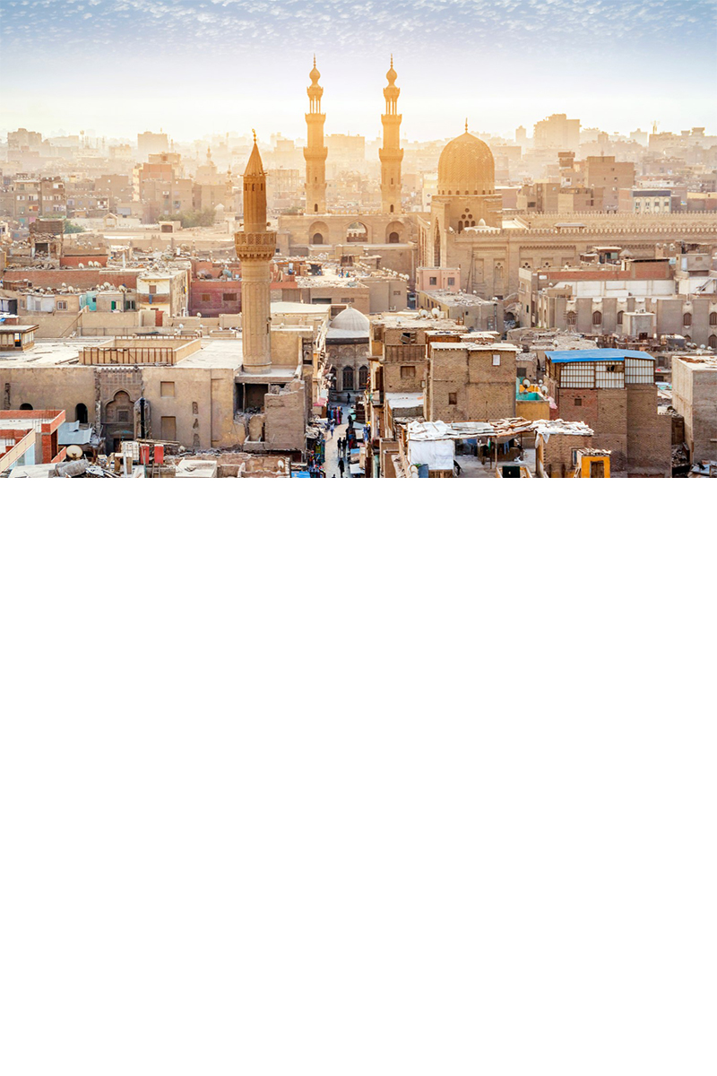 Stadtansicht von Kairo mit der beleuchteten Muhammad-Ali-Moschee und der Zitadelle bei Sonnenuntergang..