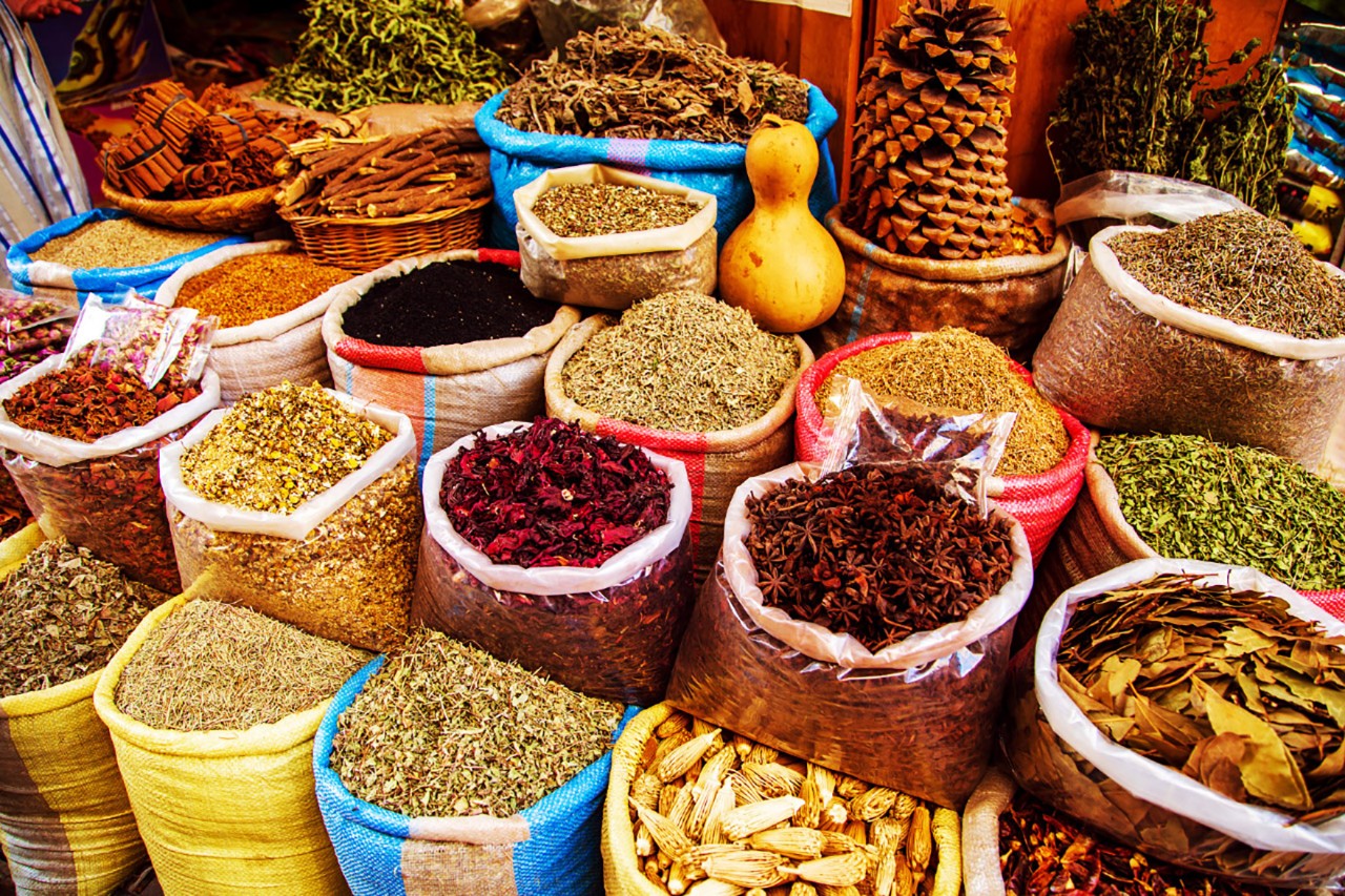 Bunter Gewürzstand mit Kegeln aus Pulver in Marrakeschs Medina.