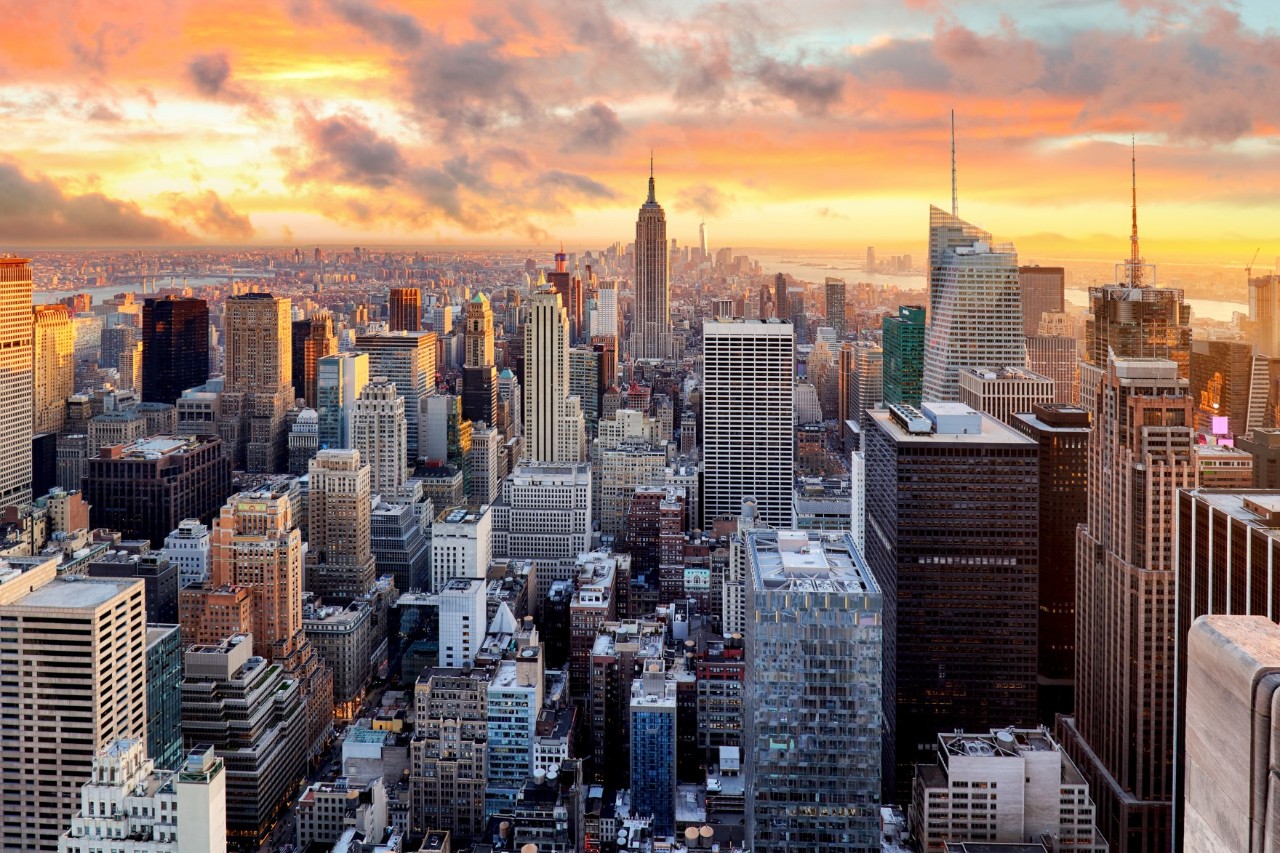 New Yorker Skyline bei Nacht mit beleuchteten Wolkenkratzern.