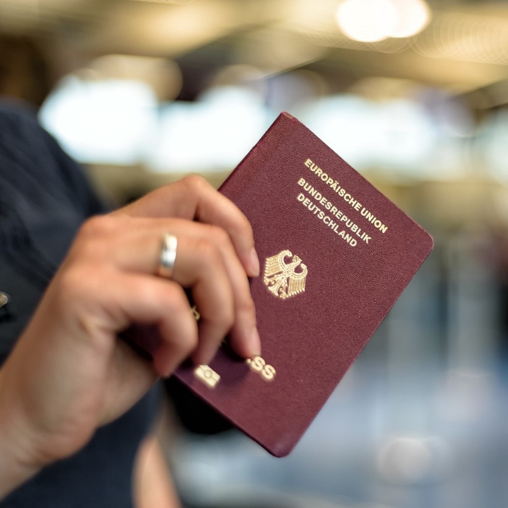 Reisepass in der Hand einer Person.