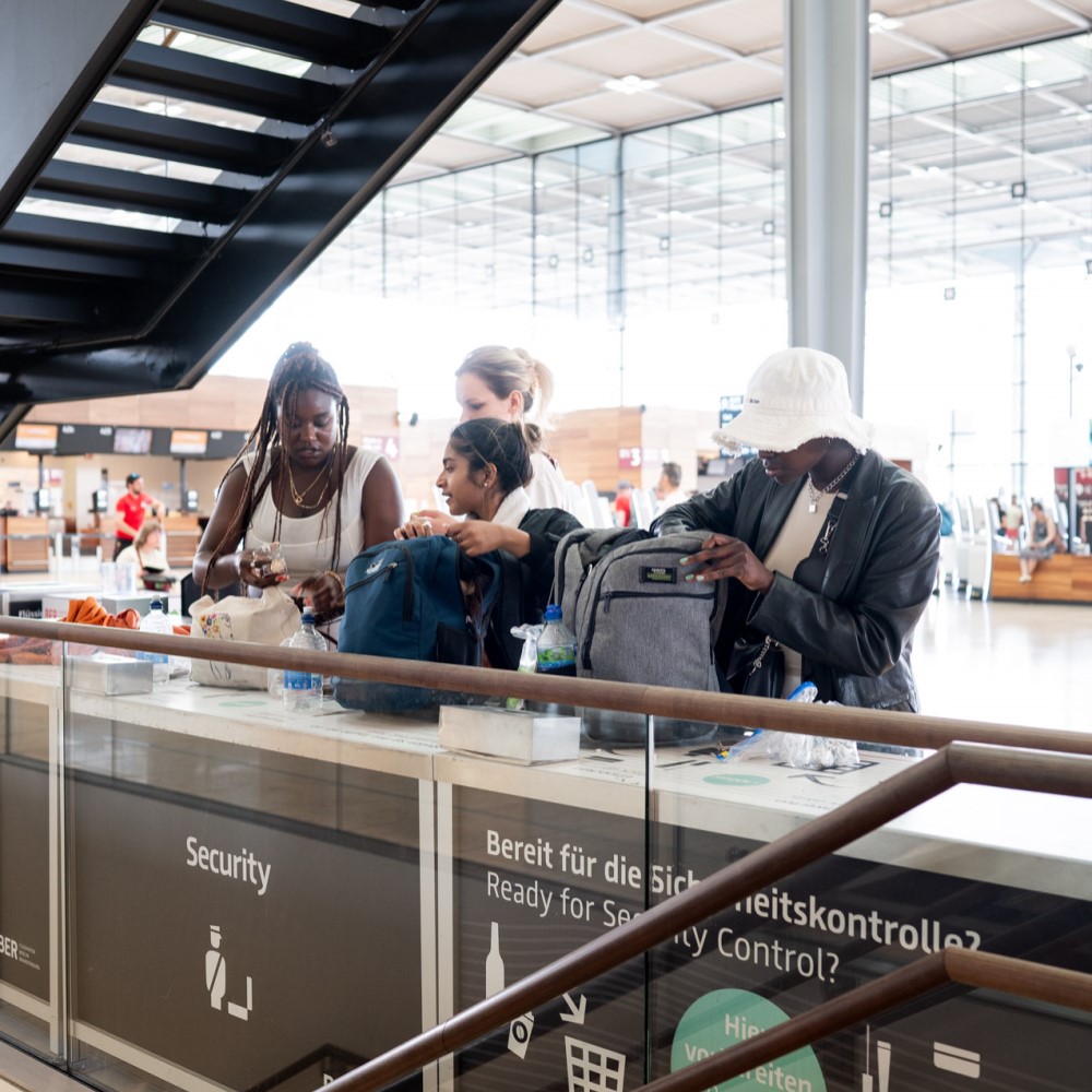 4 Frauen sortieren ihr Gepäck im Terminal 1