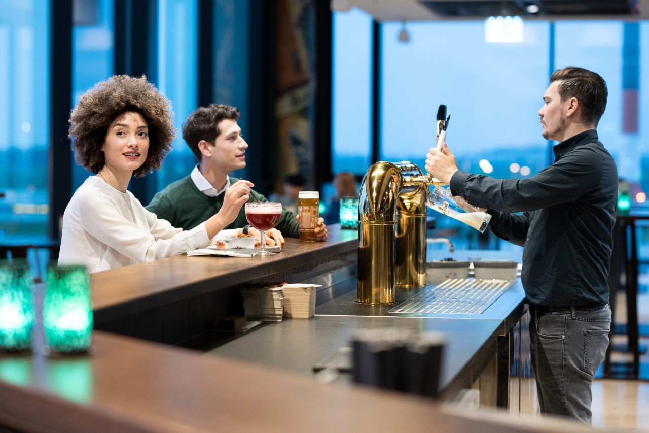 Eine Frau und ein Mann sitzen an der Bar des Berlin Pub