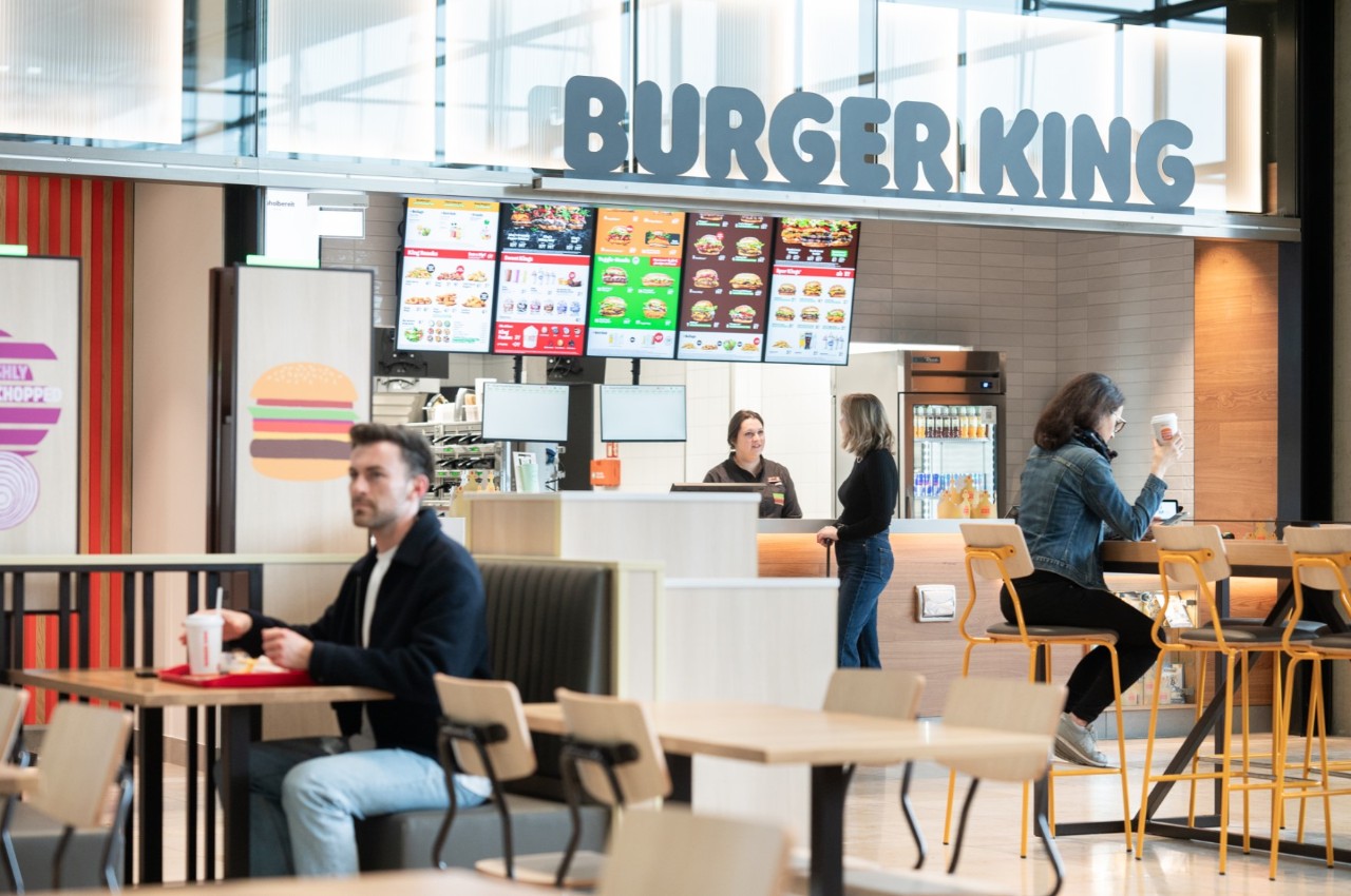 1 Person am Tisch; Eine weitere Person bestellt bei Burger King