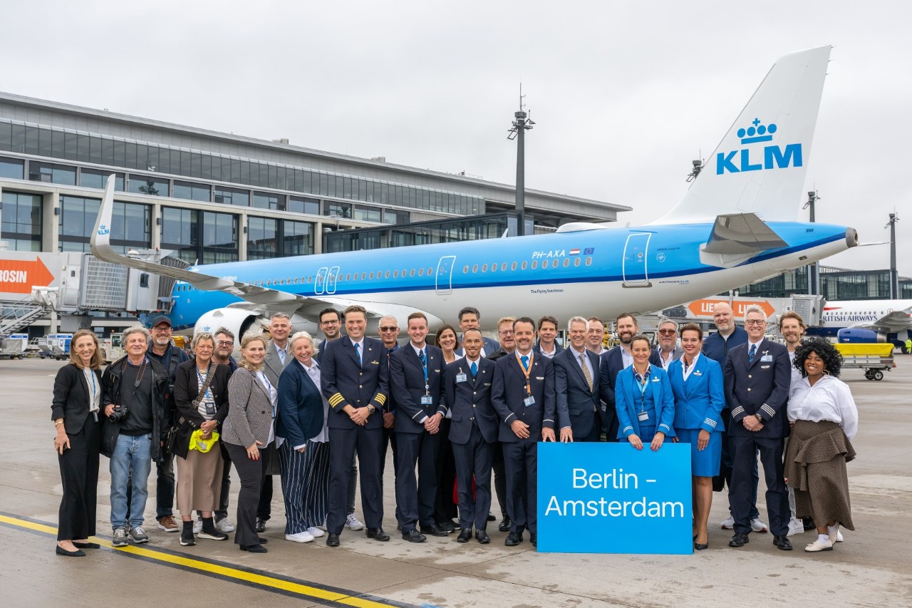 Personengruppe vor einem KLM Flugzeug auf dem Vorfeld.