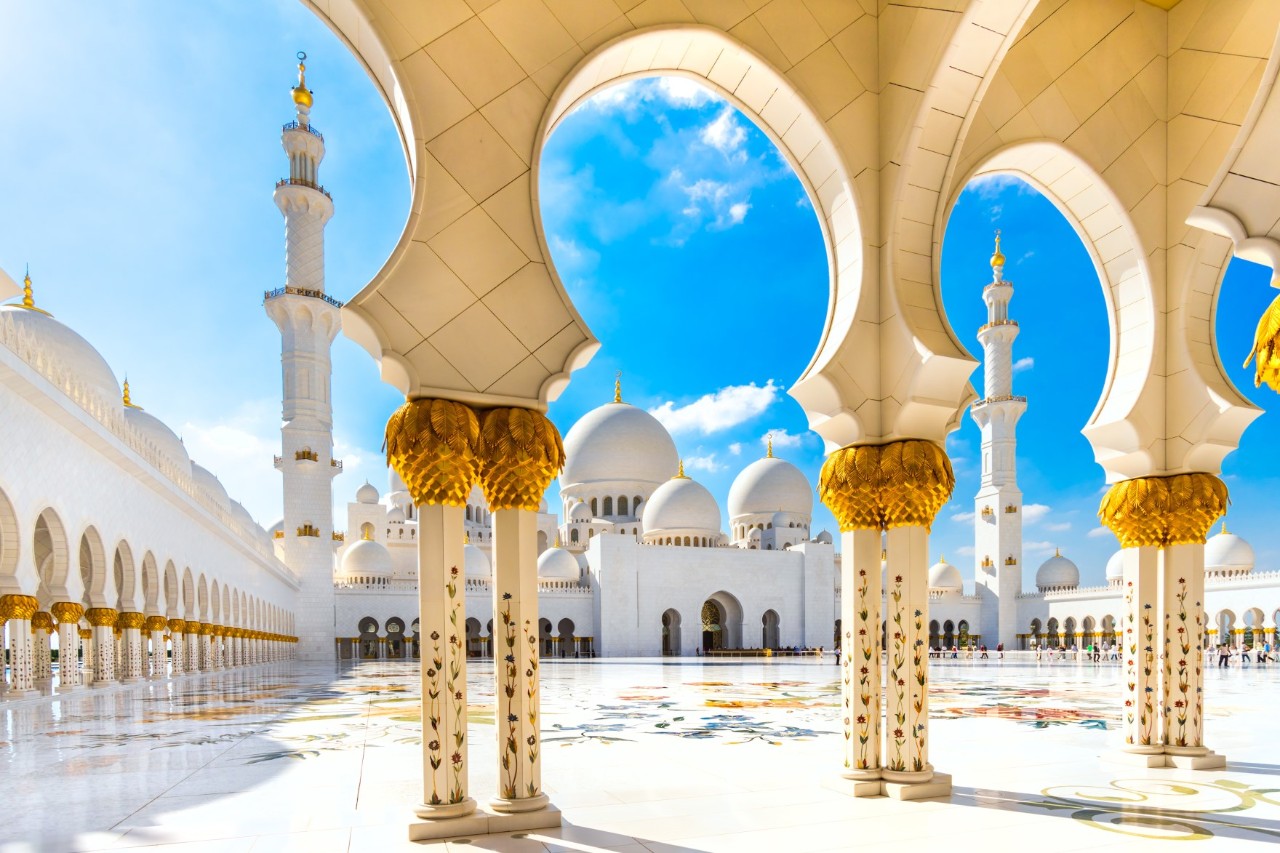 Blick aus einem Säulengang heraus auf den Innenhof eines prachtvollen Gebäudes im arabischen Baustil.