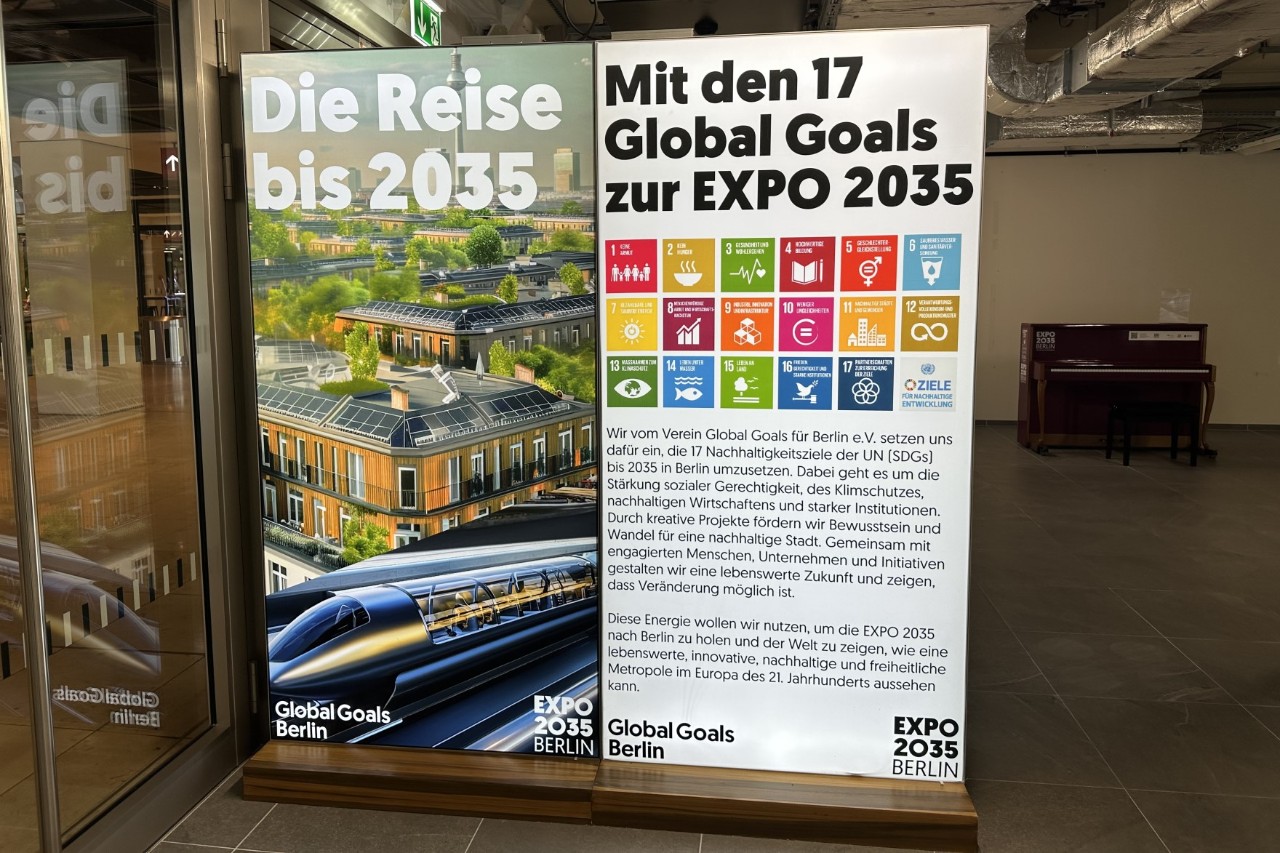 Eine Leuchtwerbetafel in einem Raum, im Hintergund ein Klavier