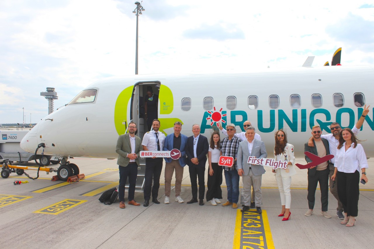 Viele Personen vor einer Maschine mit dem Aufdruck Air Uniqon
