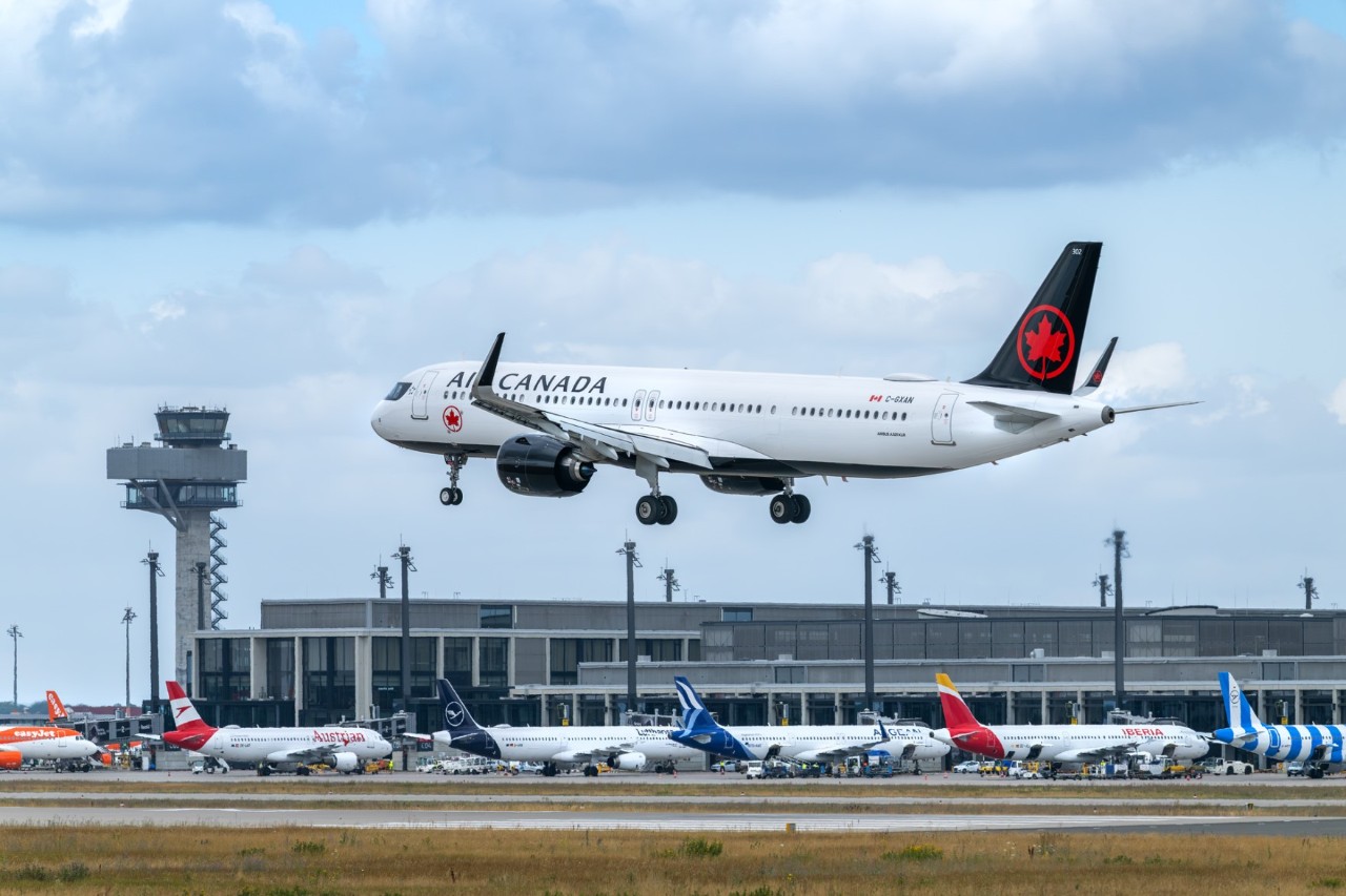 Air Canada Fluzgzeug landet am BER. Im Hintergrund der Tower sowie das Terminal 1 mit Flugzeugen