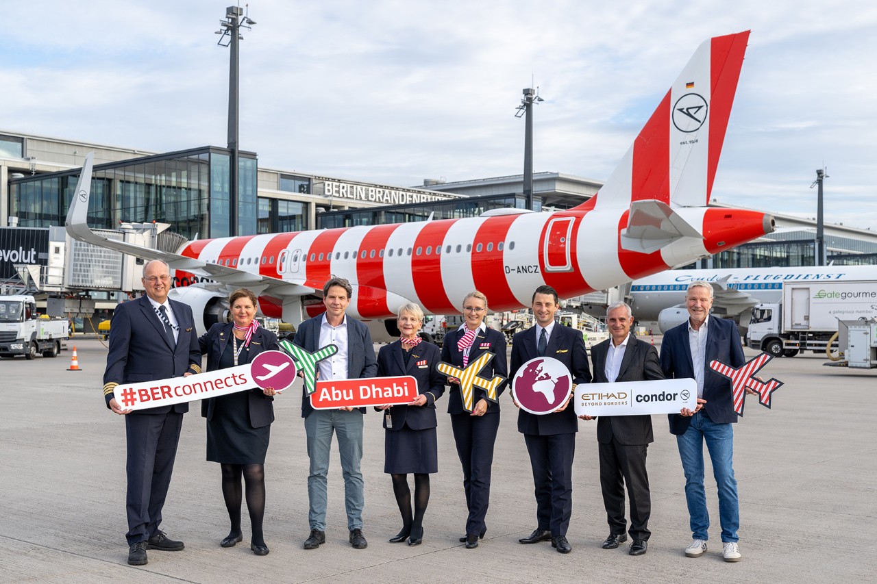 Mehrere Menschen vor einem Condor-Flugzeug mit Schildern in den Händen