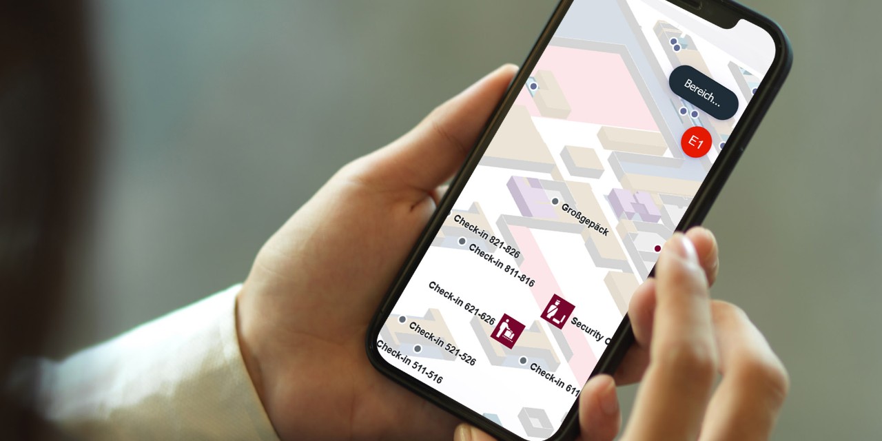 Hände halten ein Smartphone, darauf die Karte des BER 