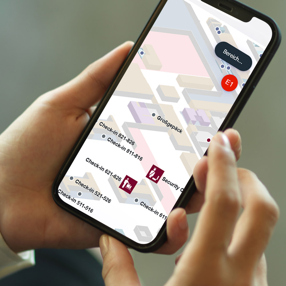 Hände halten ein Smartphone, darauf die Karte des BER 